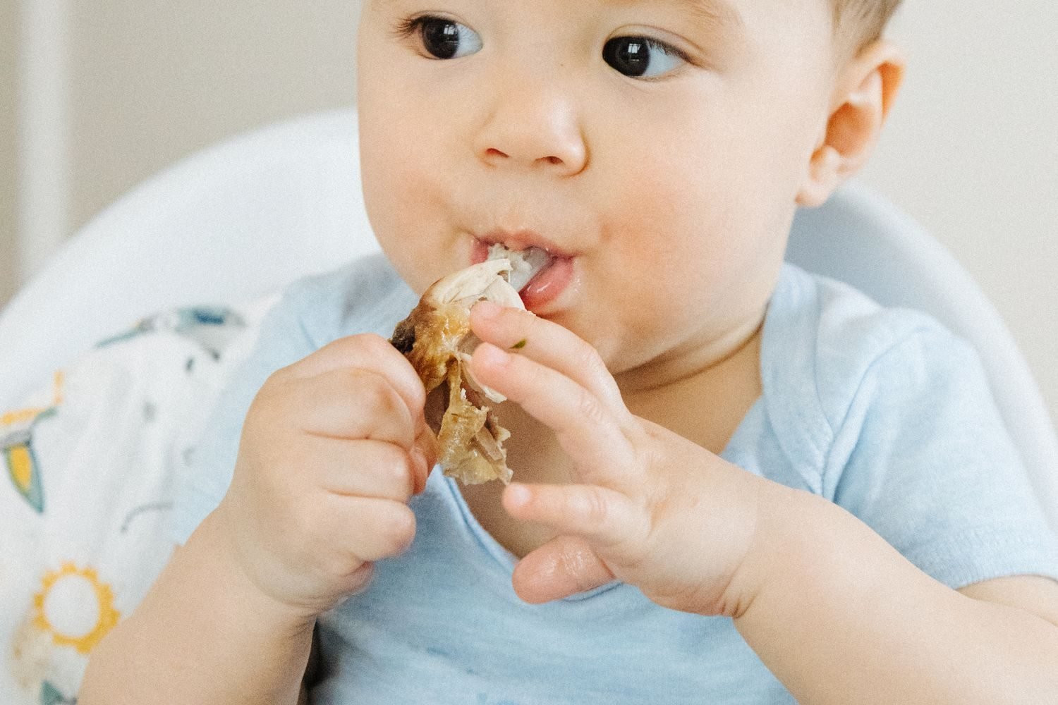 Toddler exploring different colorful foods and textures during a family meal