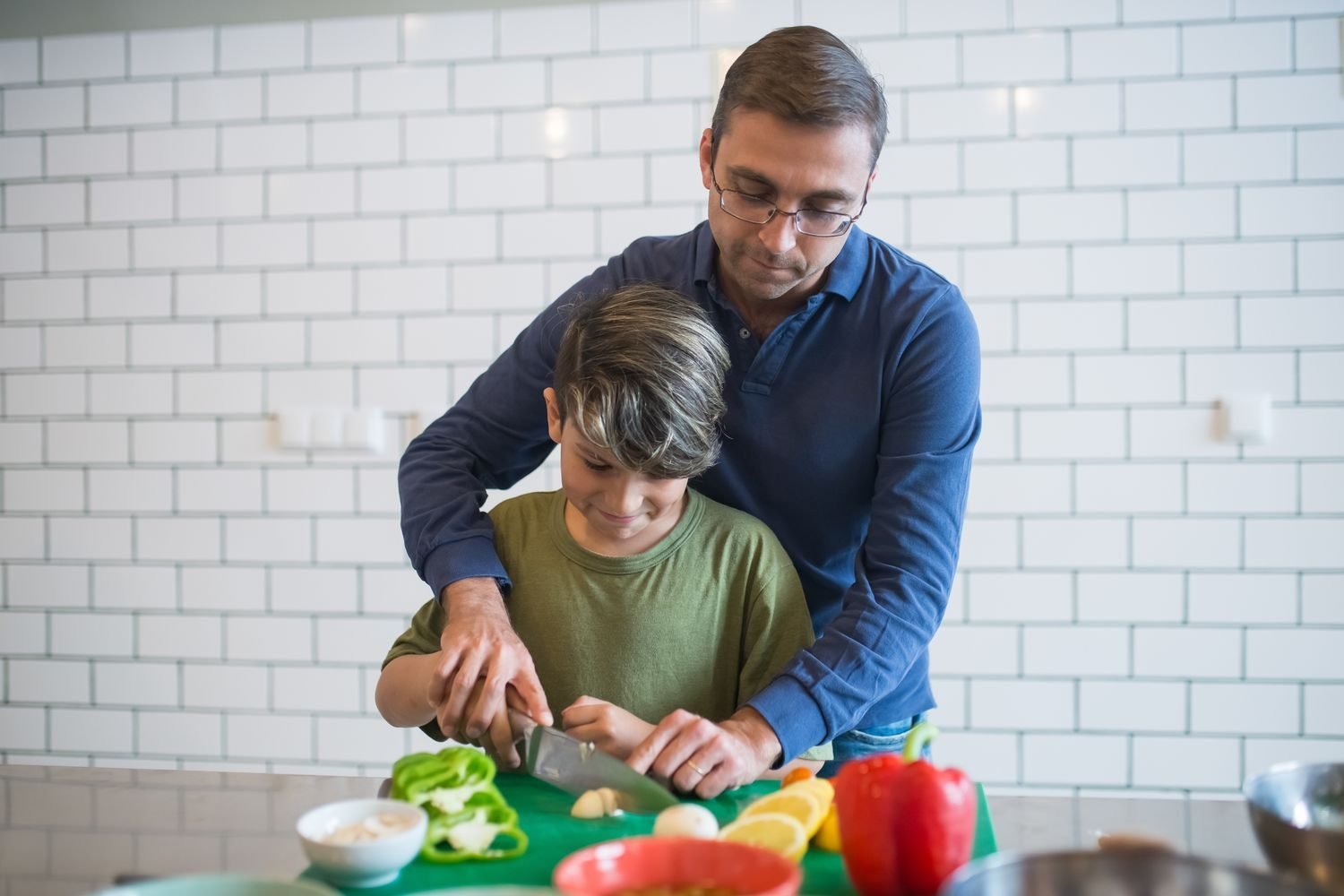 Parent and child preparing fresh vegetables together in the kitchen
