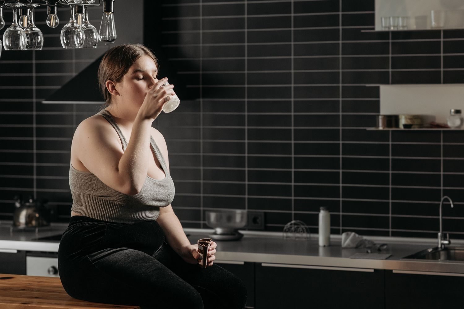 Person drinking water during a fasting window as part of easing into intermittent fasting