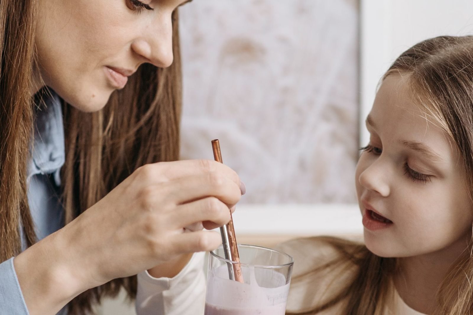 Parent reading the nutrition label on a malted milk health drink tin in a kitchen