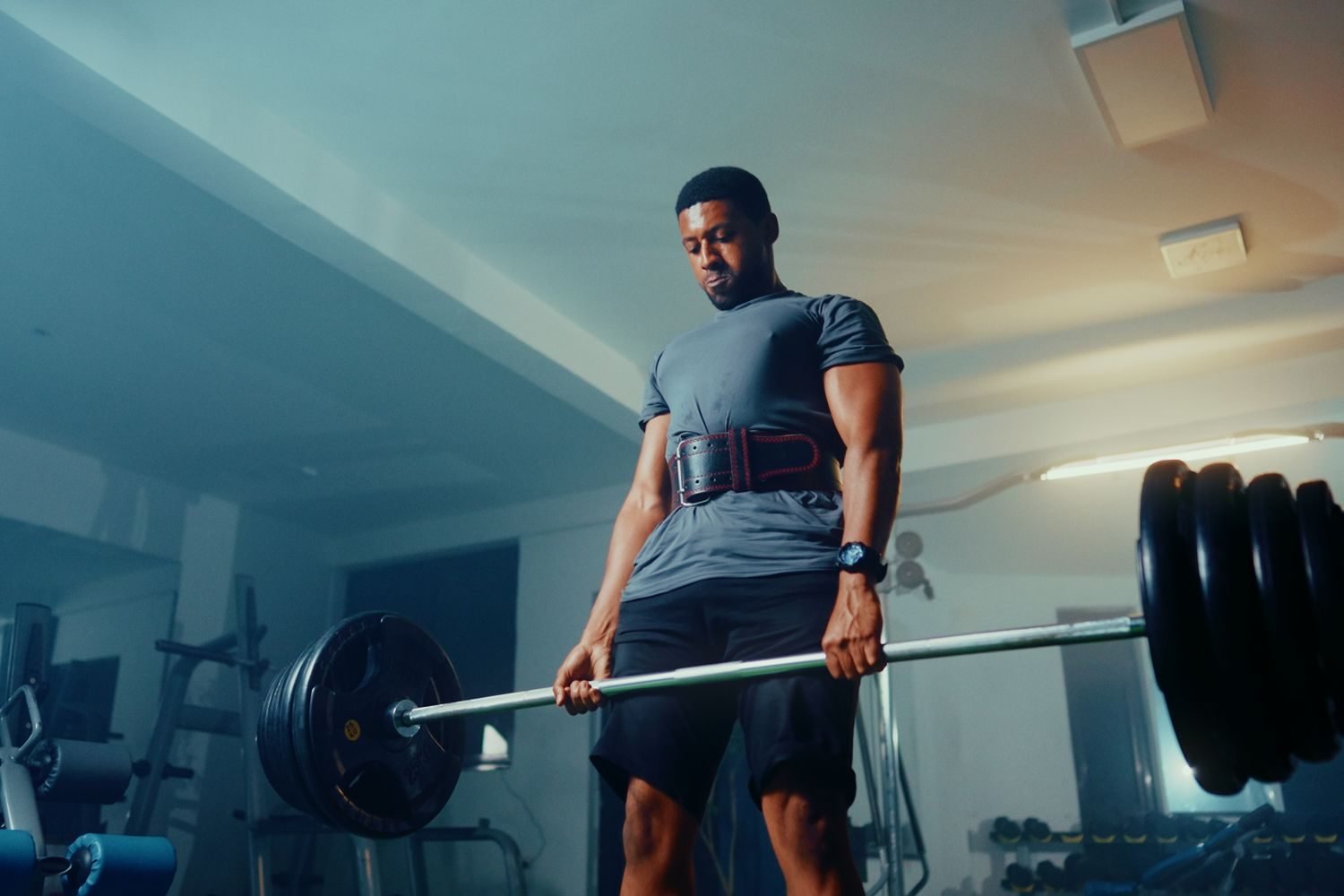Man performing a barbell deadlift during a leg day session at the gym