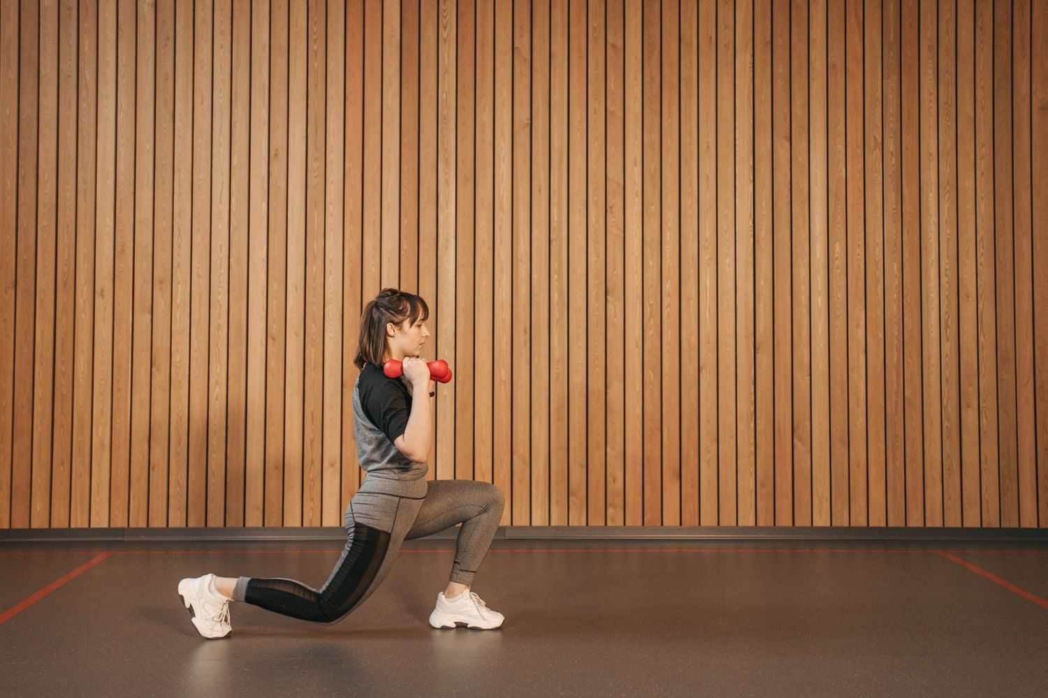 Woman performing a walking lunge with dumbbells