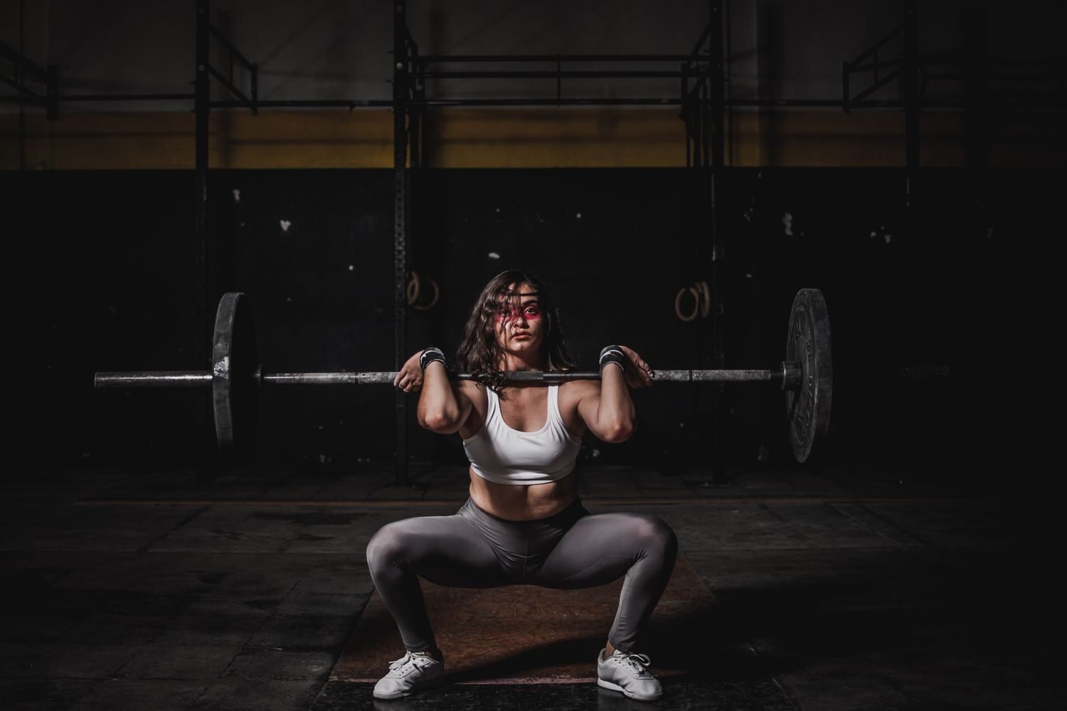 Woman performing a front barbell squat at the gym
