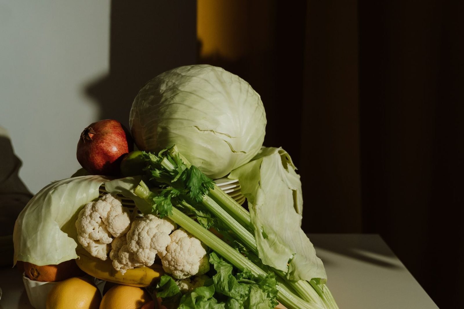 Assorted whole foods including citrus fruits, leafy greens, dairy, and lean meats representing sources of essential vitamins and minerals