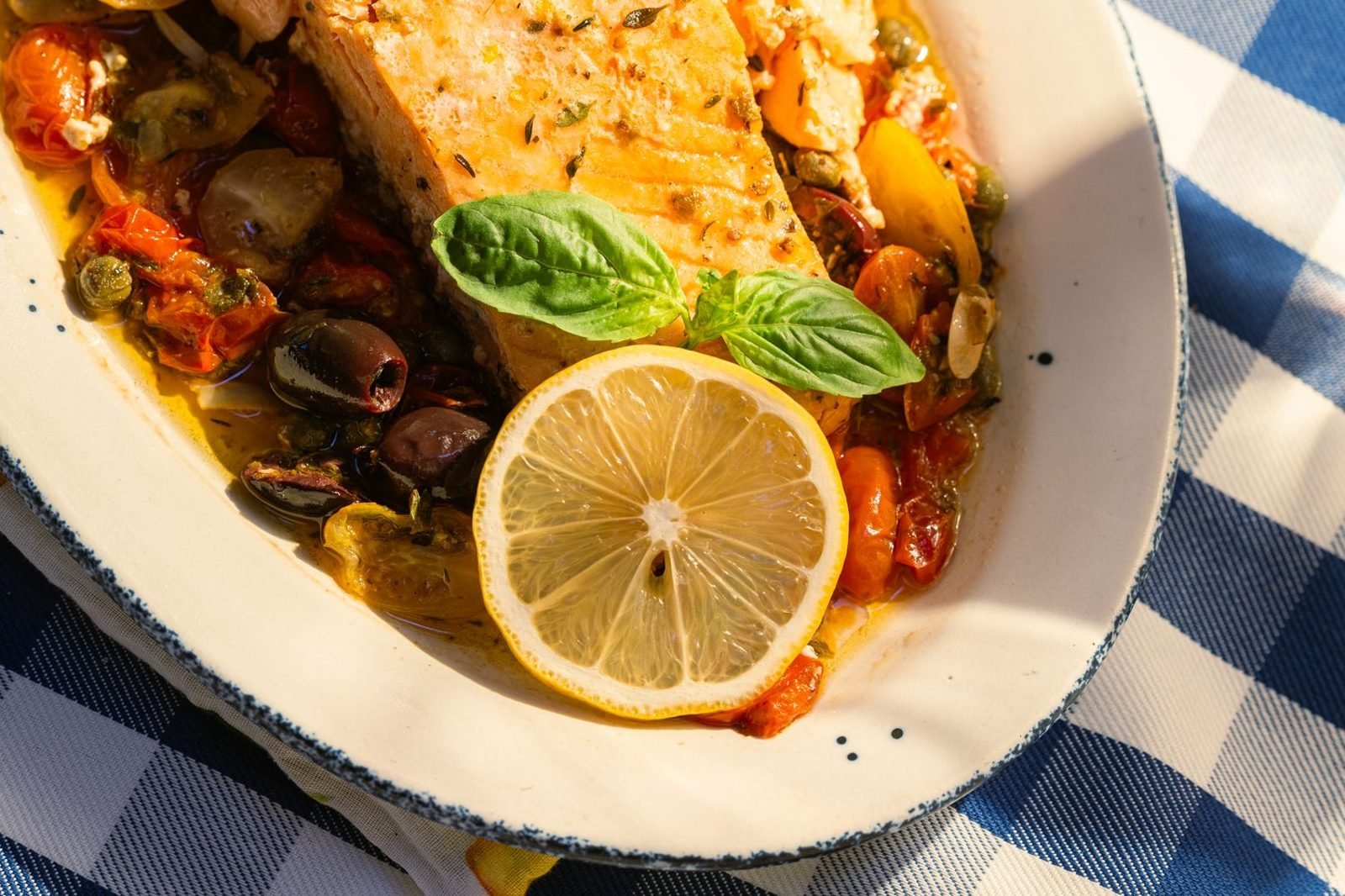 Mediterranean-style plate with leafy greens, olive oil, salmon, and whole grains for liver health