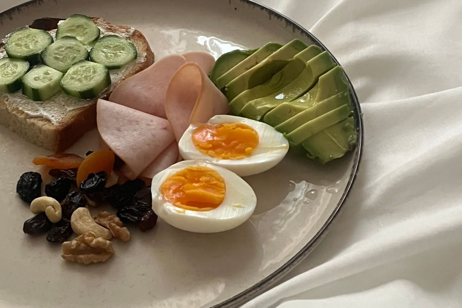 Balanced plate comparing low-carb foods like eggs, vegetables and nuts against grains and fruit