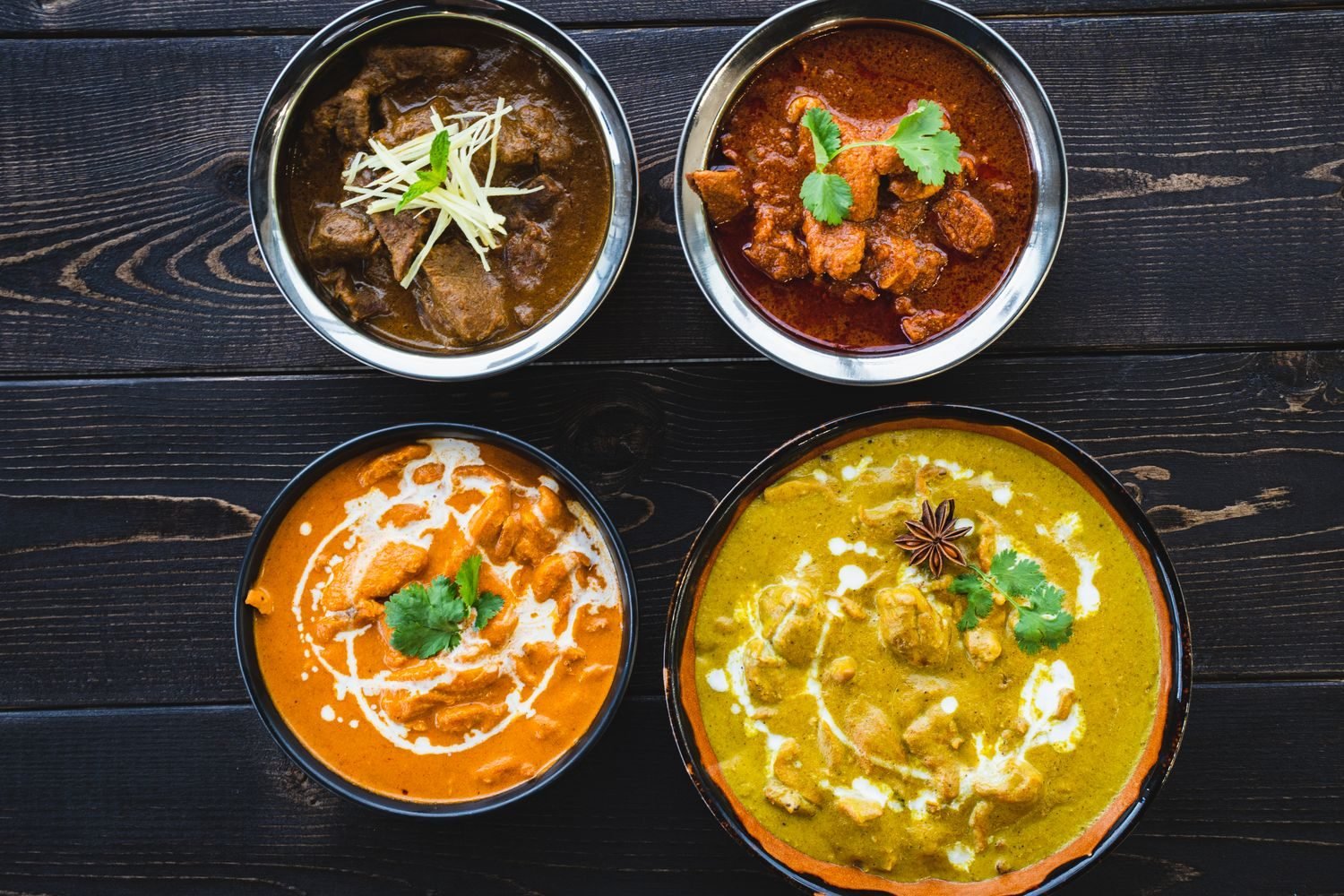 A day of low-carb Indian meals including paneer bhurji, grilled chicken tikka, palak sabzi and moong dal in small bowls