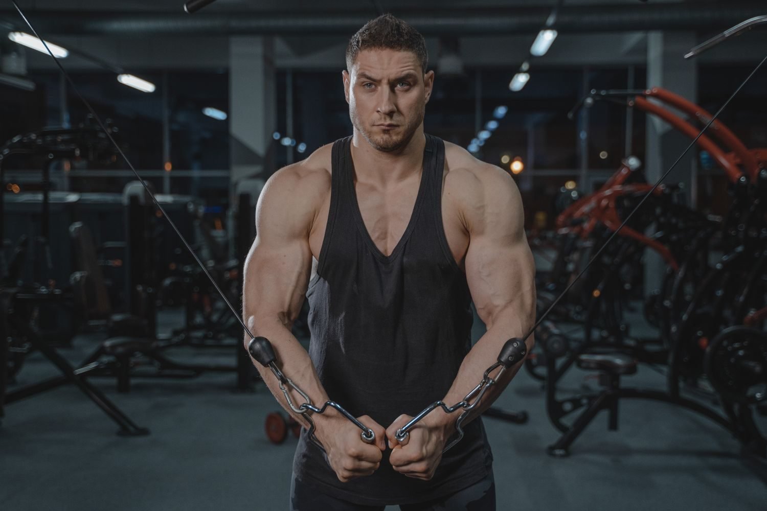 Man performing a low cable crossover exercise targeting the lower chest