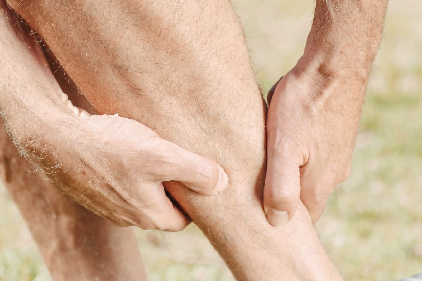 Person rubbing a cramping calf muscle, illustrating a common early sign of low magnesium status