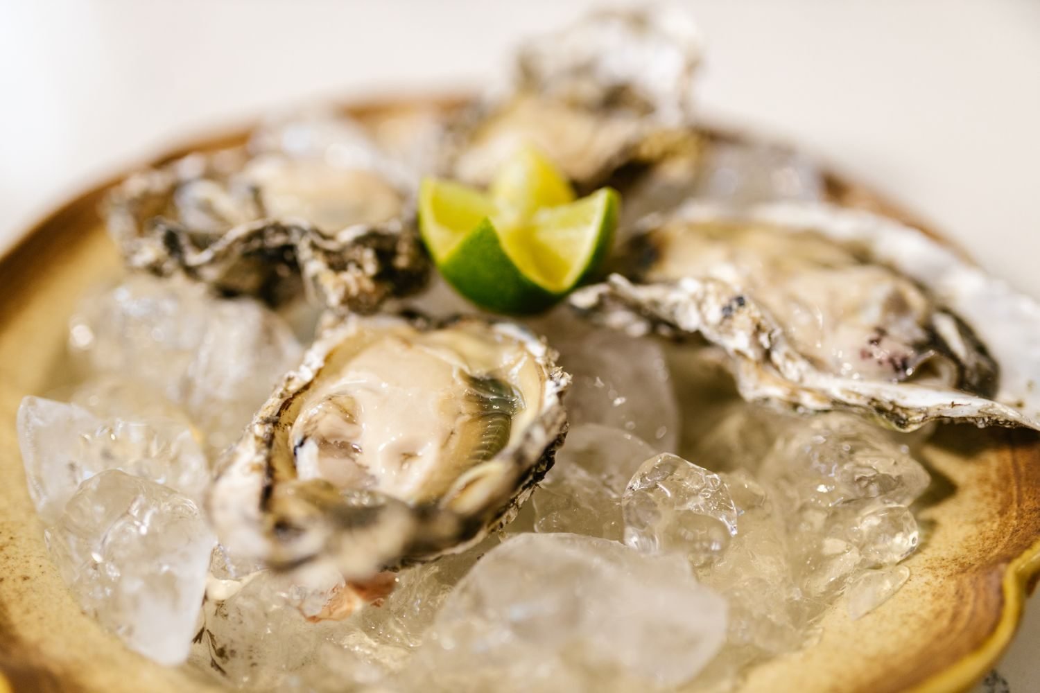 Zinc-rich and healthy-fat foods for men including oysters, beef, chickpeas, and olive oil arranged on a table