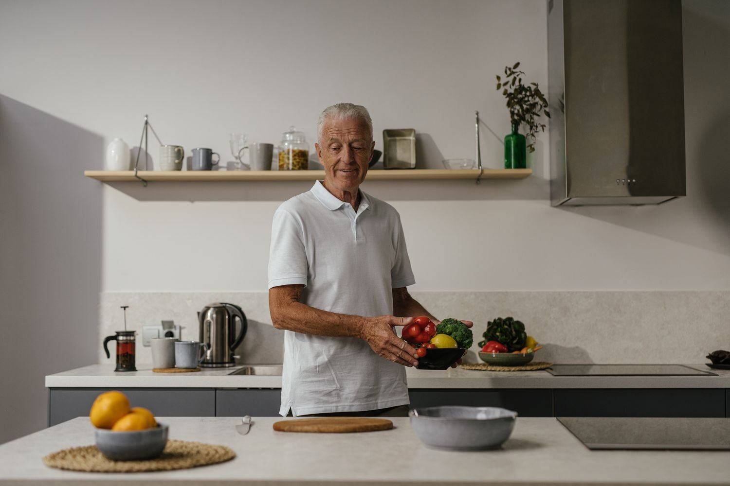 Man in his 40s preparing a balanced meal with vegetables, lean protein, and whole grains at home