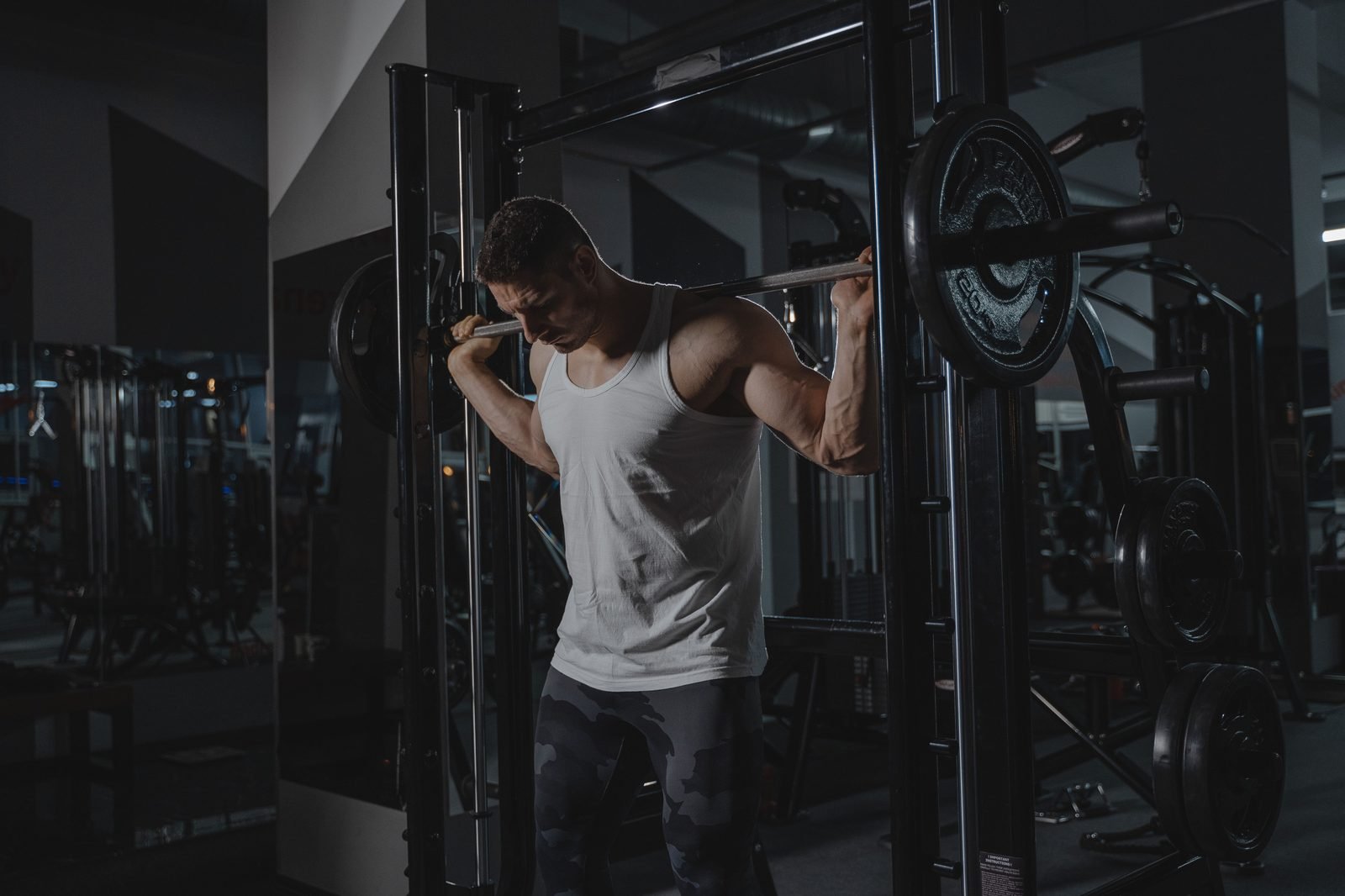 Man performing a barbell squat in the gym