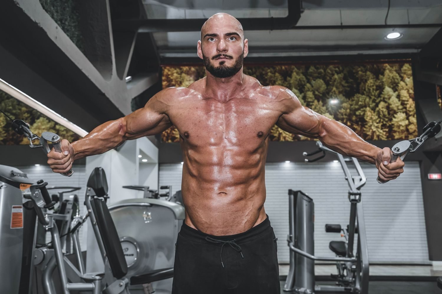 Muscular man performing a cable crossover chest exercise