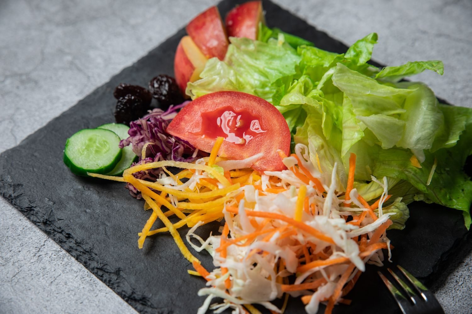 Fresh vegetables and fruits on a plate, representing low-calorie foods often mislabeled as fat-burning