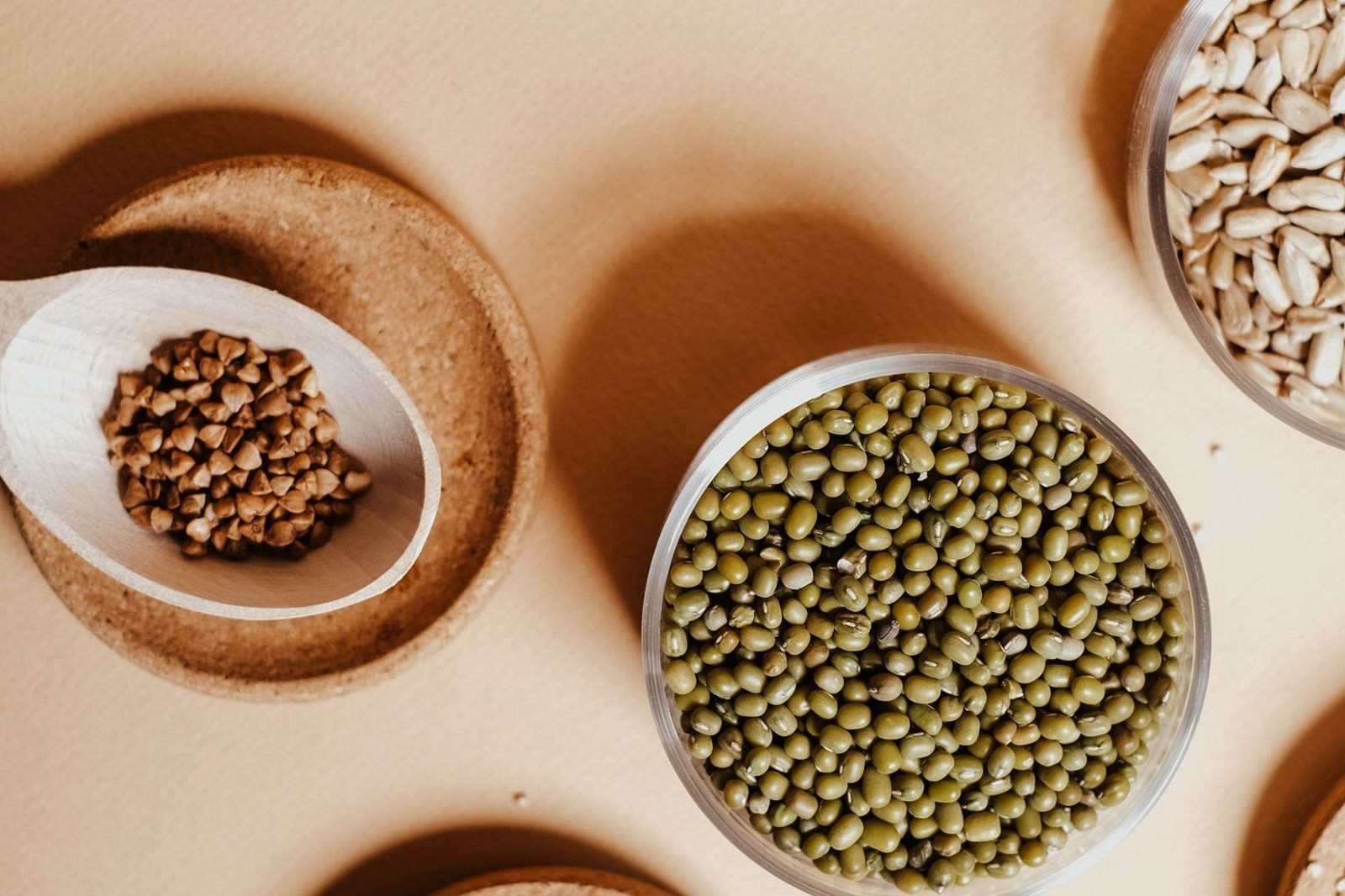 Assortment of colorful whole foods including leafy greens, lentils, dairy, nuts and grains representing dietary variety