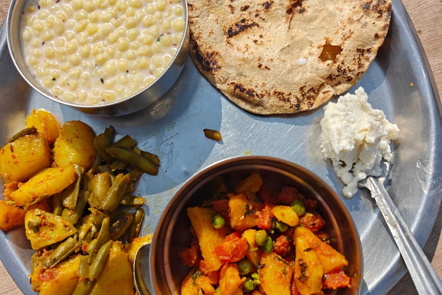 Person eating a balanced meal with vegetables, curd, and whole grains for gut health