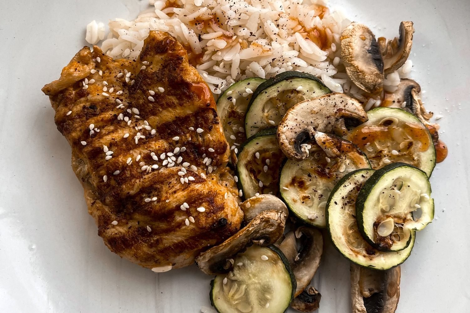 Post-workout meal with grilled chicken, rice, and vegetables next to a protein shake