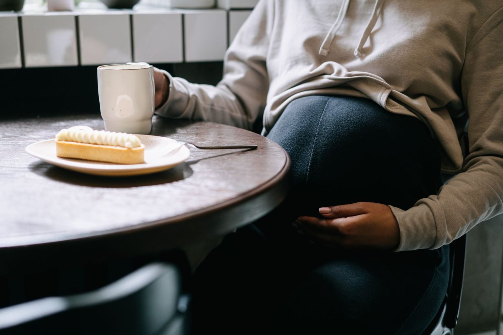 Pregnant woman preparing a light pre-workout snack of banana and almonds before a walk