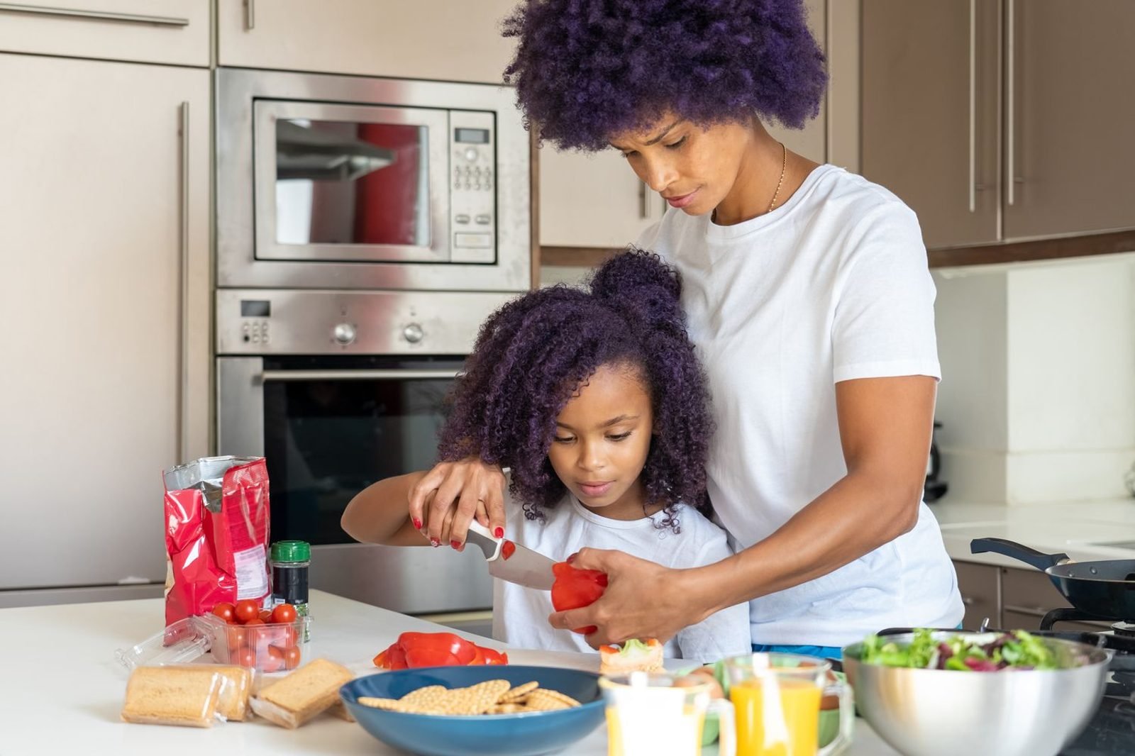 Parent and child preparing a healthy snack together in the kitchen