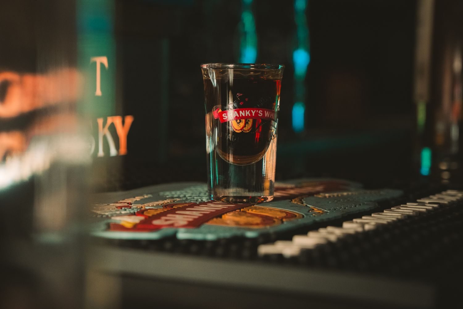 Glass of whisky and beer next to a calorie tracking notebook representing alcohol calorie awareness for men