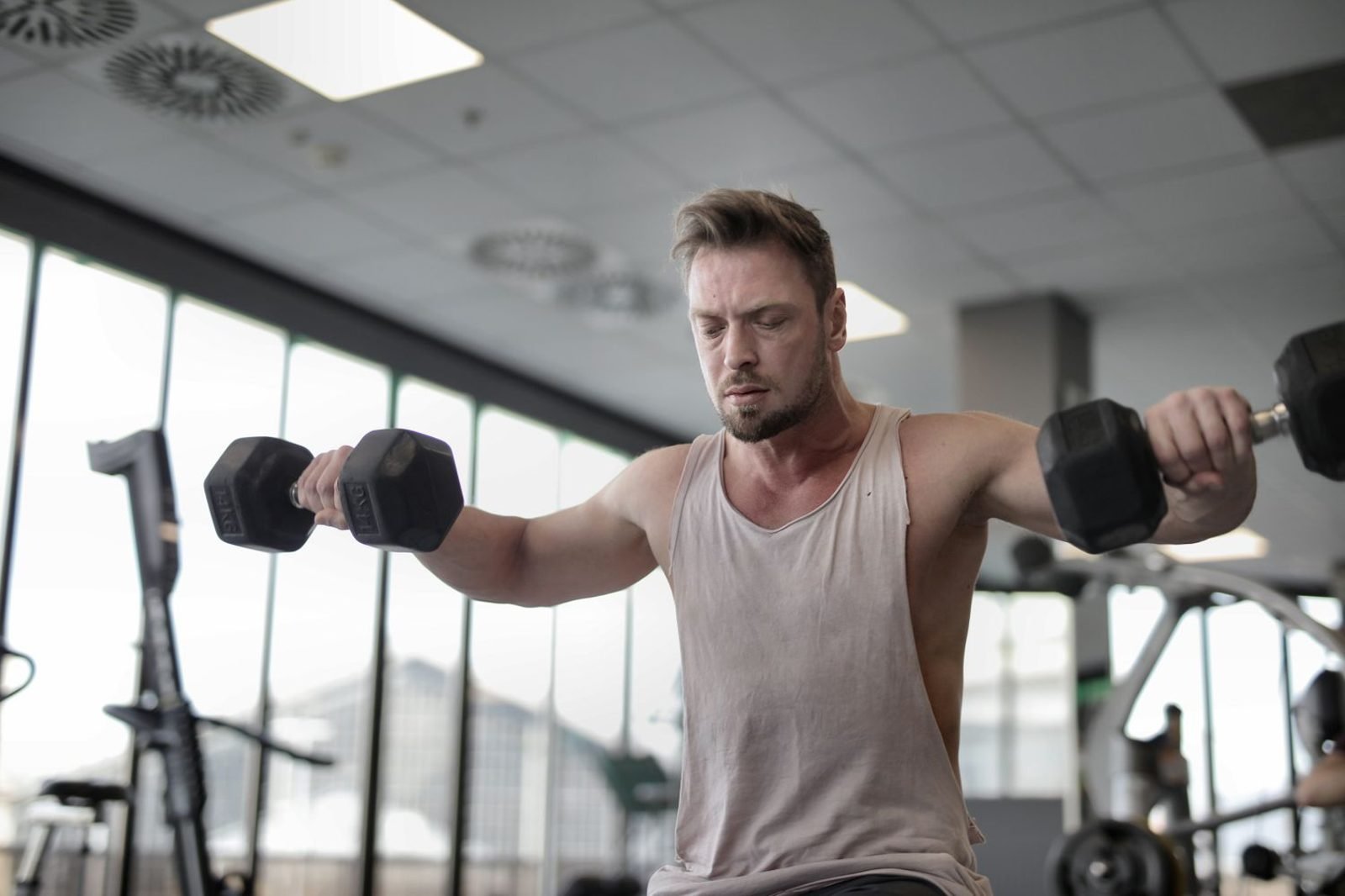 Person doing resistance training with dumbbells to build lean muscle mass during weight gain