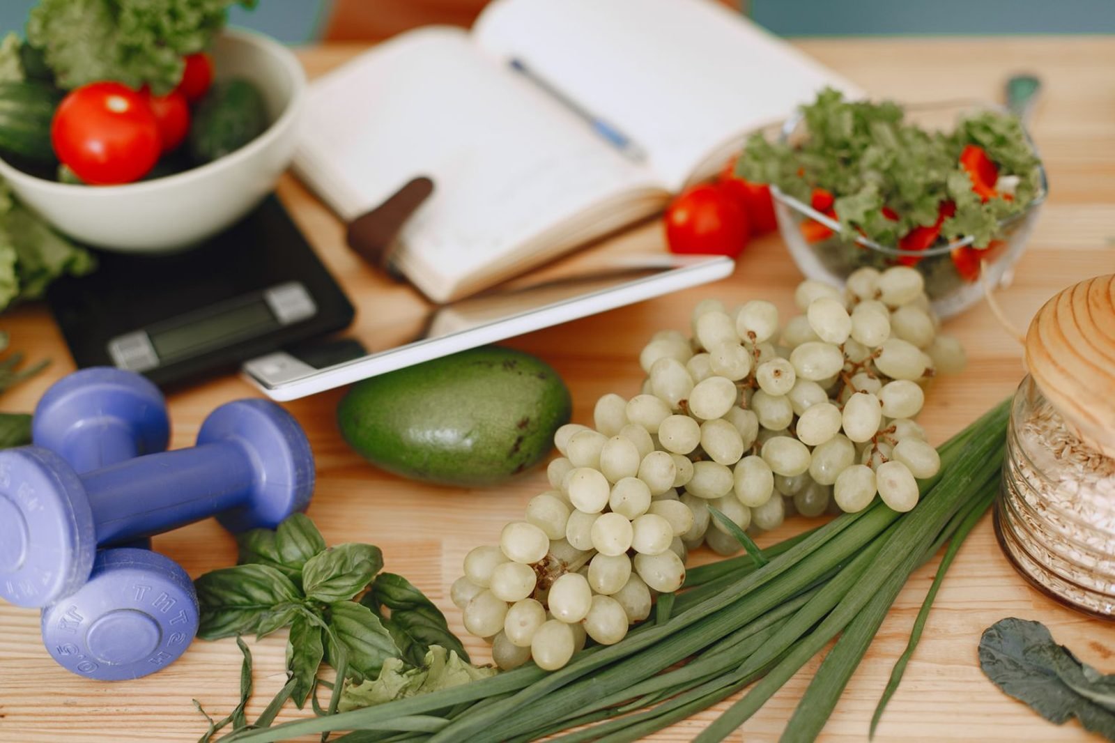 Person reviewing a balanced weight loss meal plan with multivitamin supplement and fresh produce