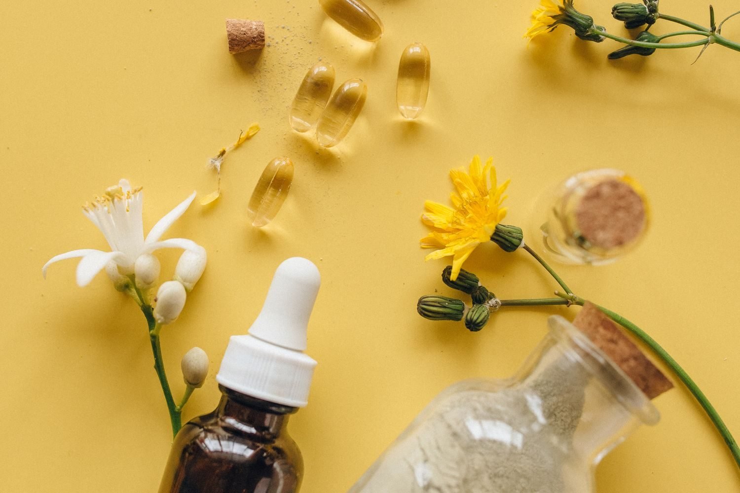 Dropper bottle of infant vitamin D supplement next to a breastfeeding baby