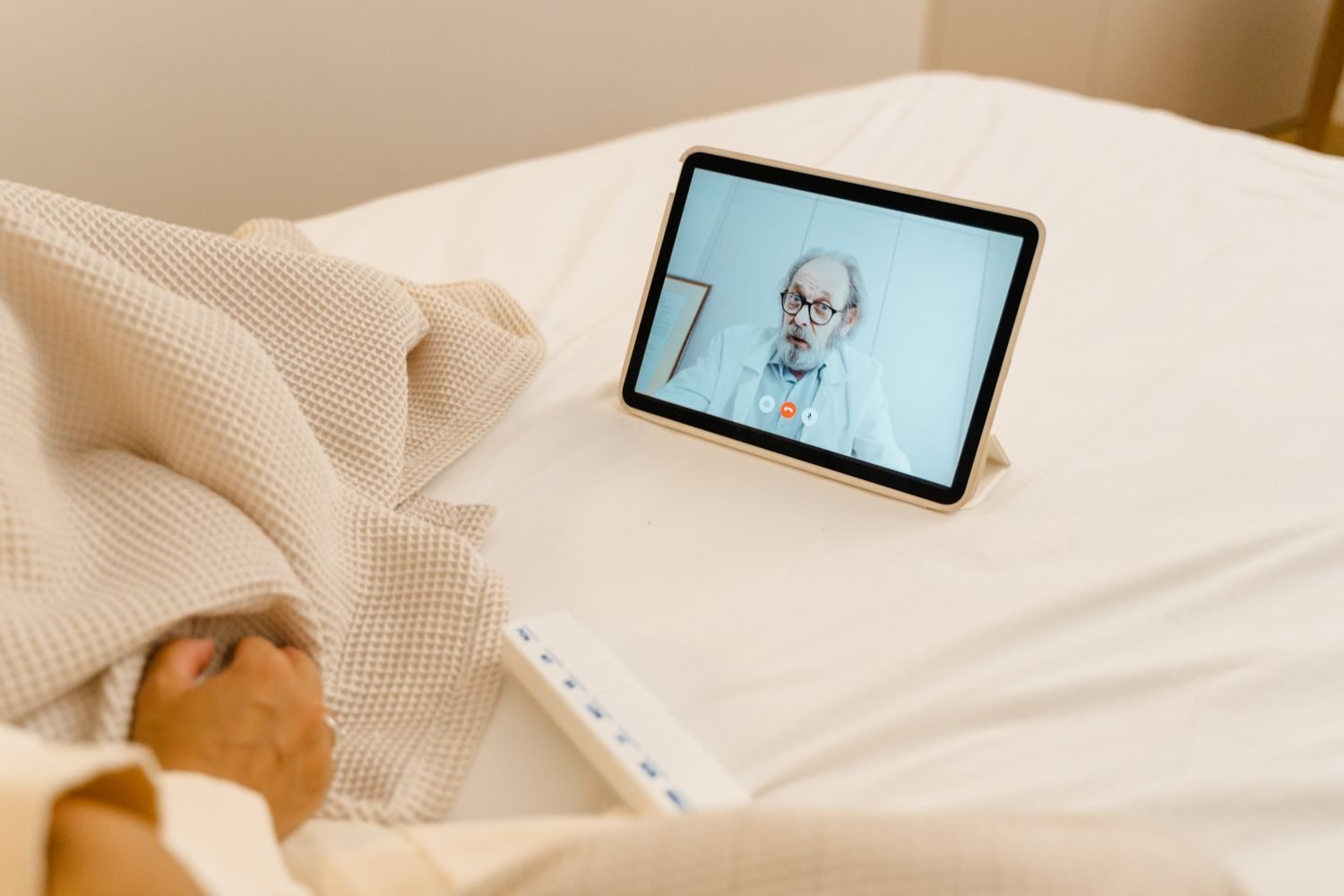 Person video calling an online nutrition professional from home, laptop showing a diet plan and consultation notes