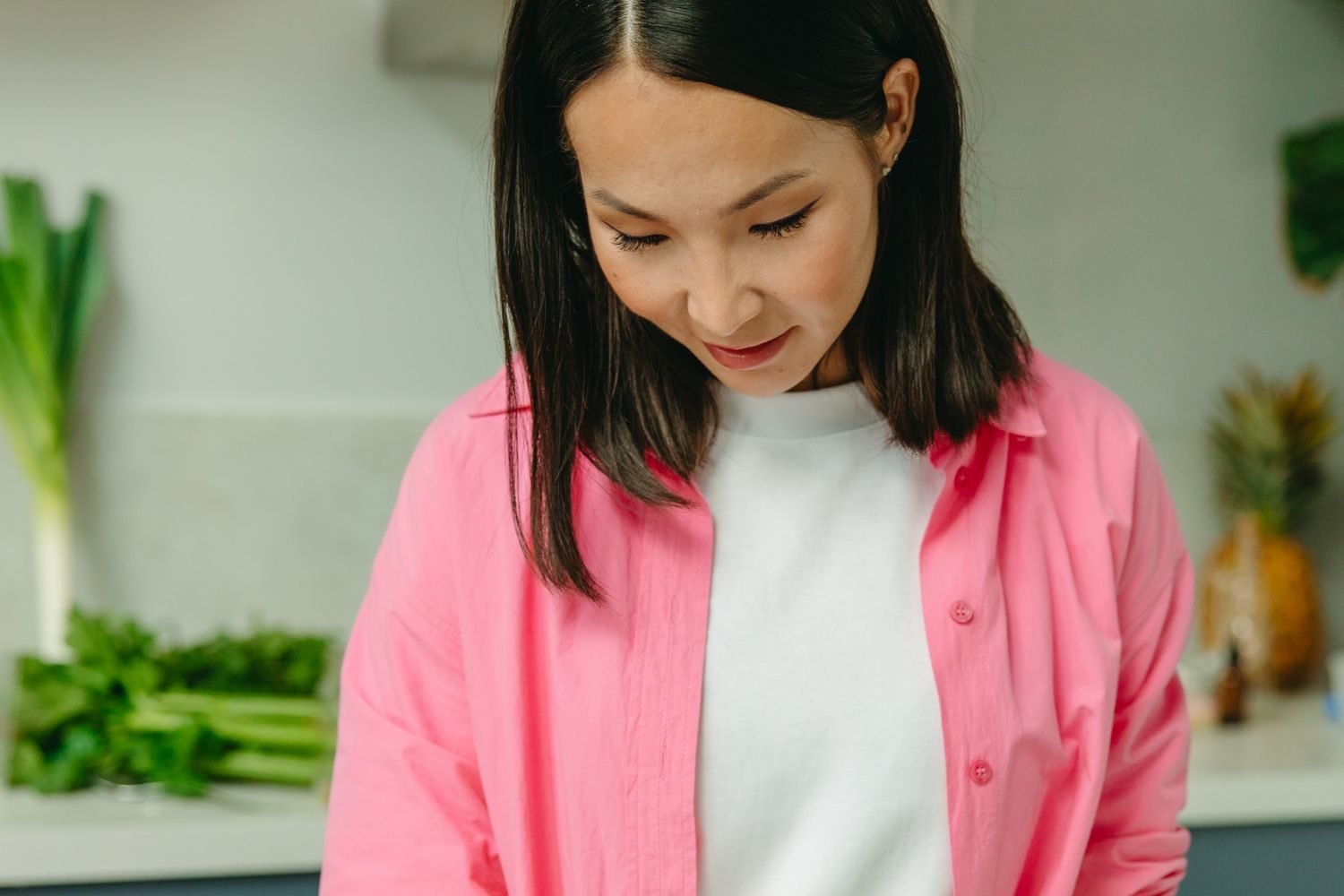 Woman tracking perimenopause symptoms and meal timing in a journal alongside healthy food