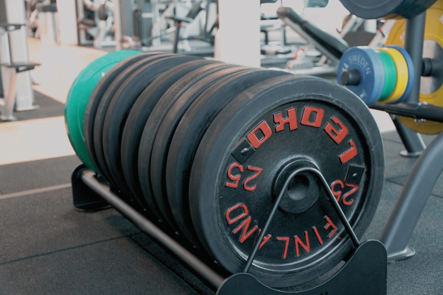 Close-up of weight plates loaded on a gym rack