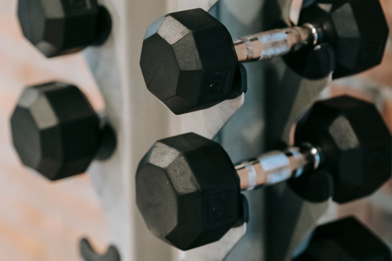 Close-up of dumbbells stacked on a gym rack