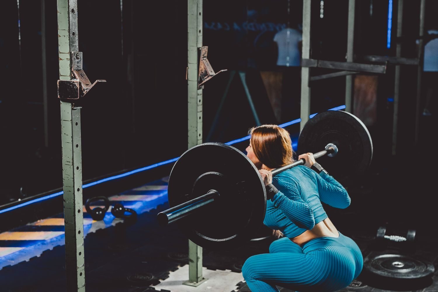 Woman performing a barbell back squat during a leg day workout