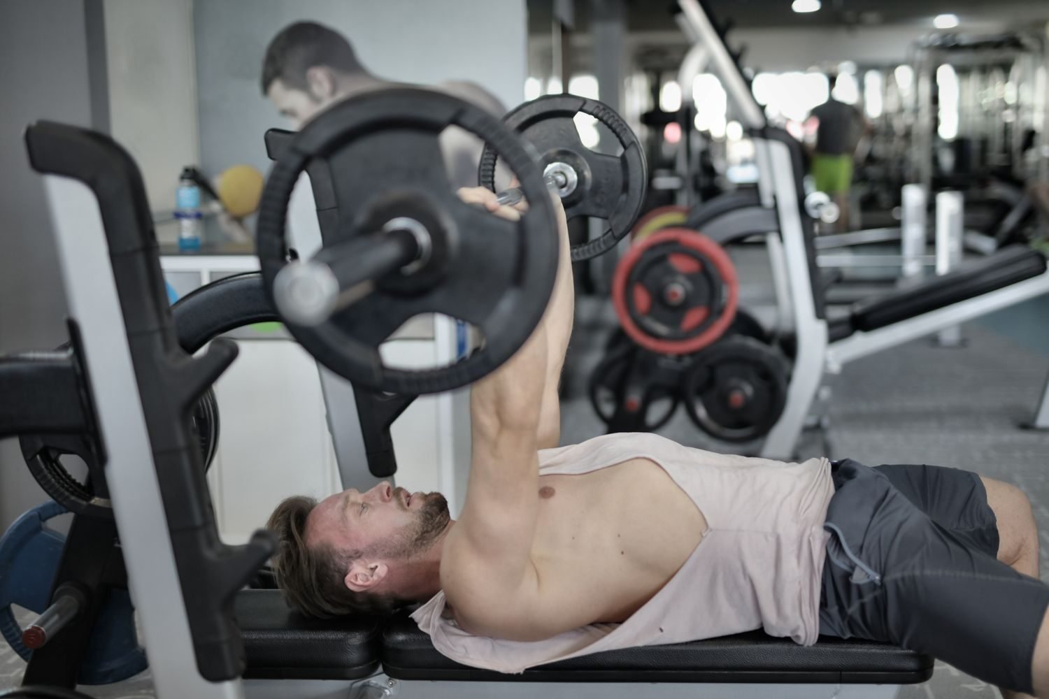 Man performing a barbell bench press for a push day in a push pull legs workout