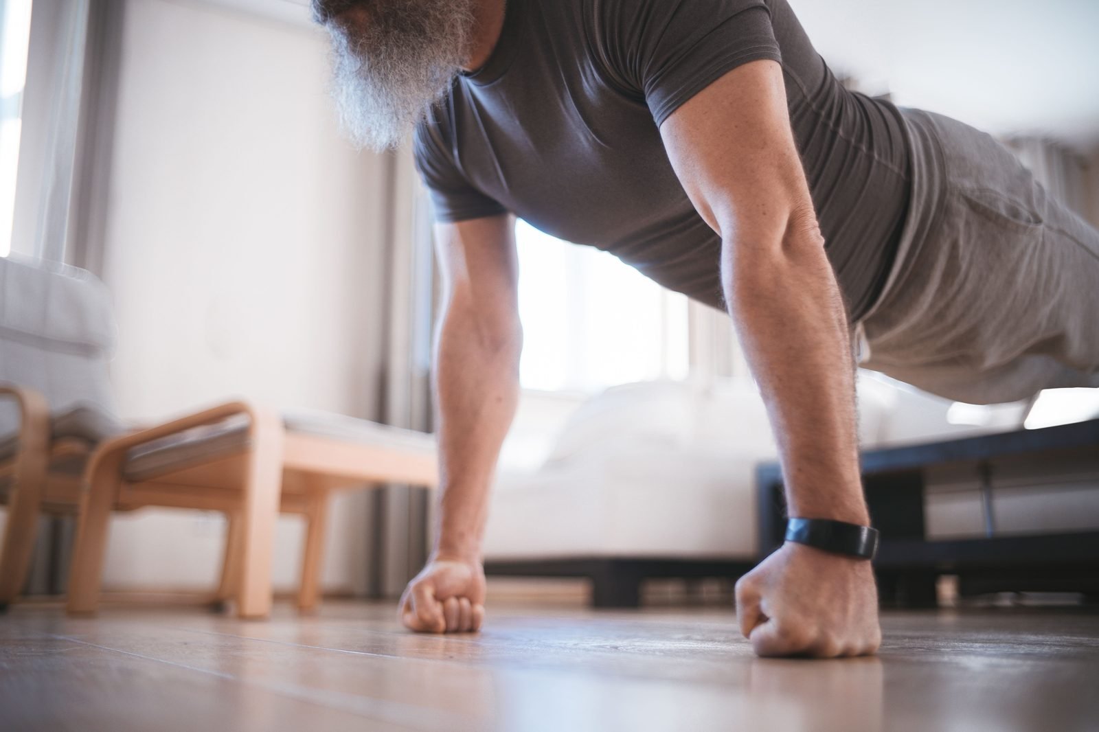 Man doing a push-up at home as part of a weekly workout plan