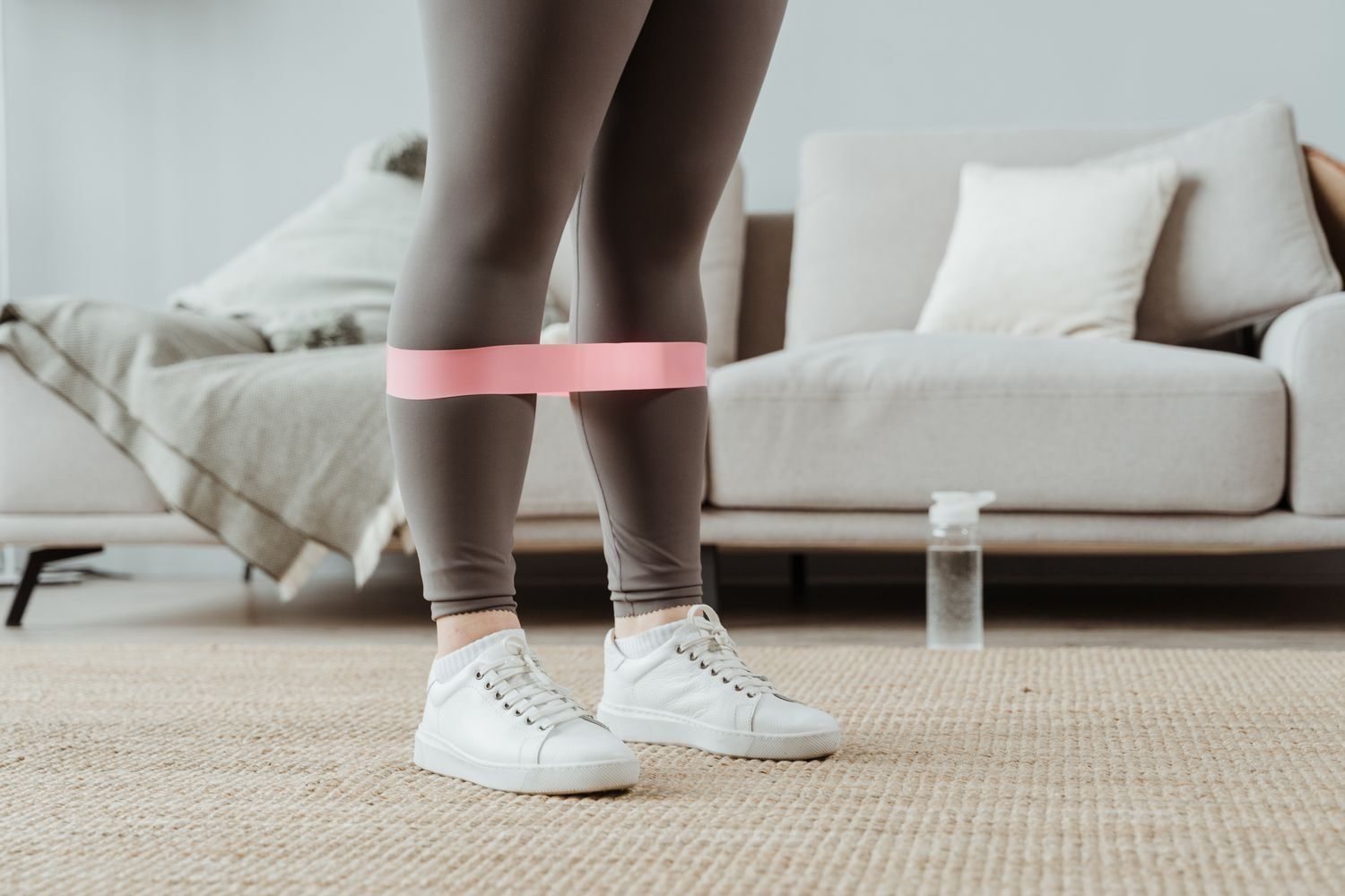 Resistance band wrapped around the legs during a home exercise