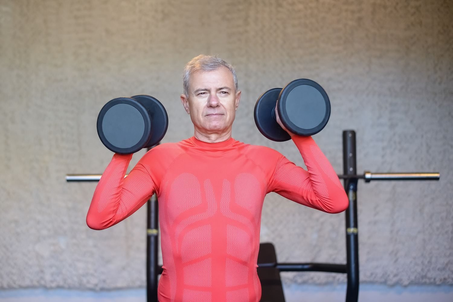 Older adult doing resistance training with dumbbells to preserve muscle mass and metabolic rate