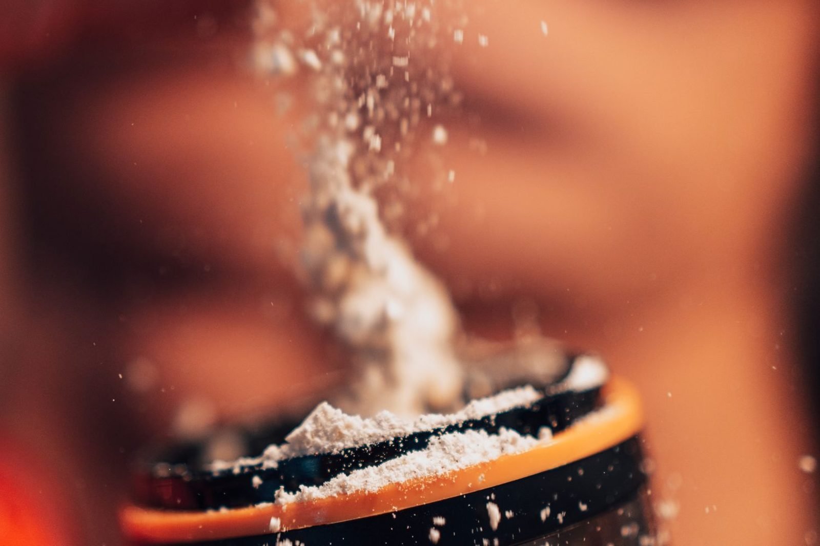 Person mixing a protein shake after a workout in the gym