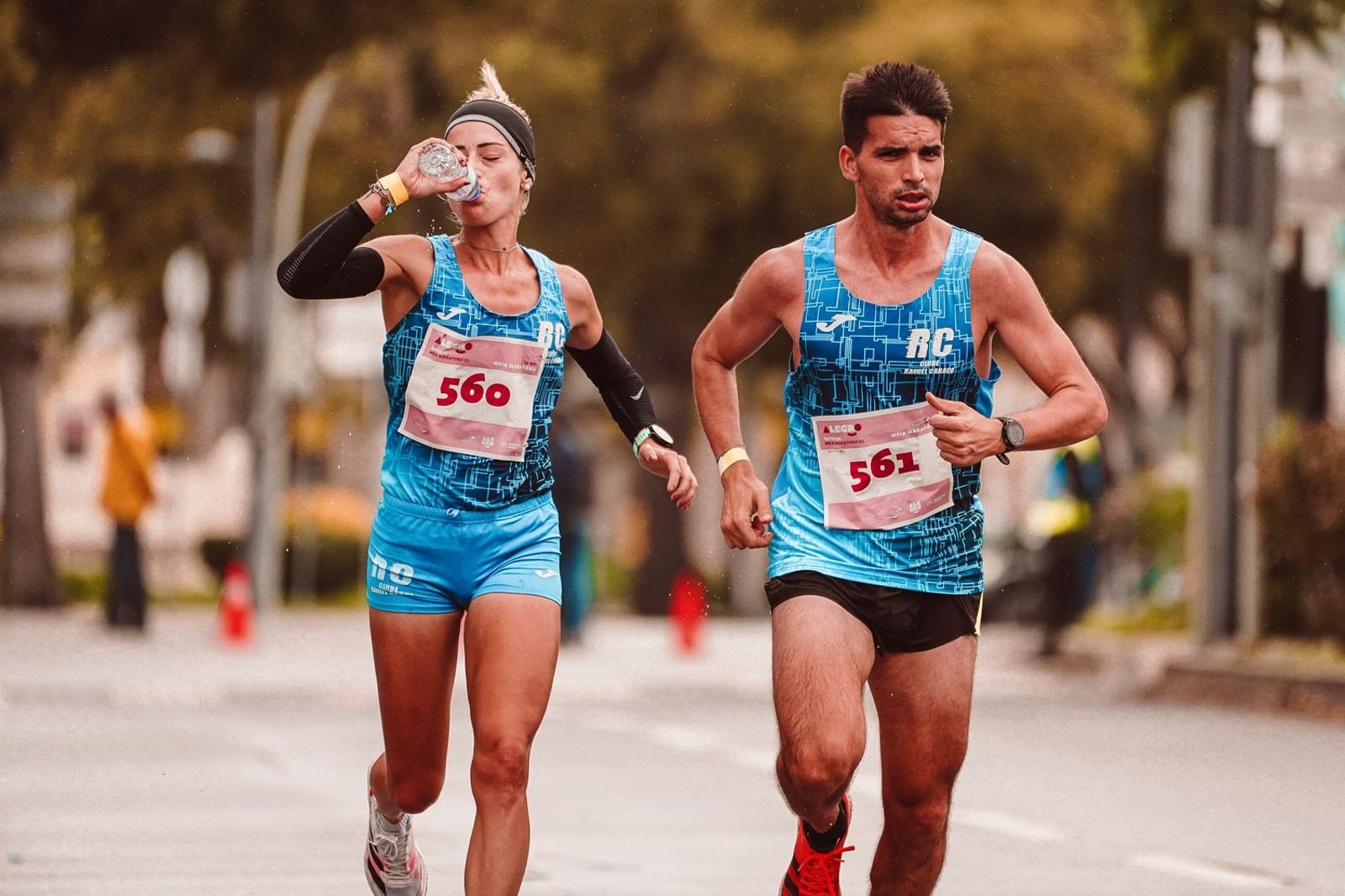 Runner drinking water from a bottle during outdoor training for hydration