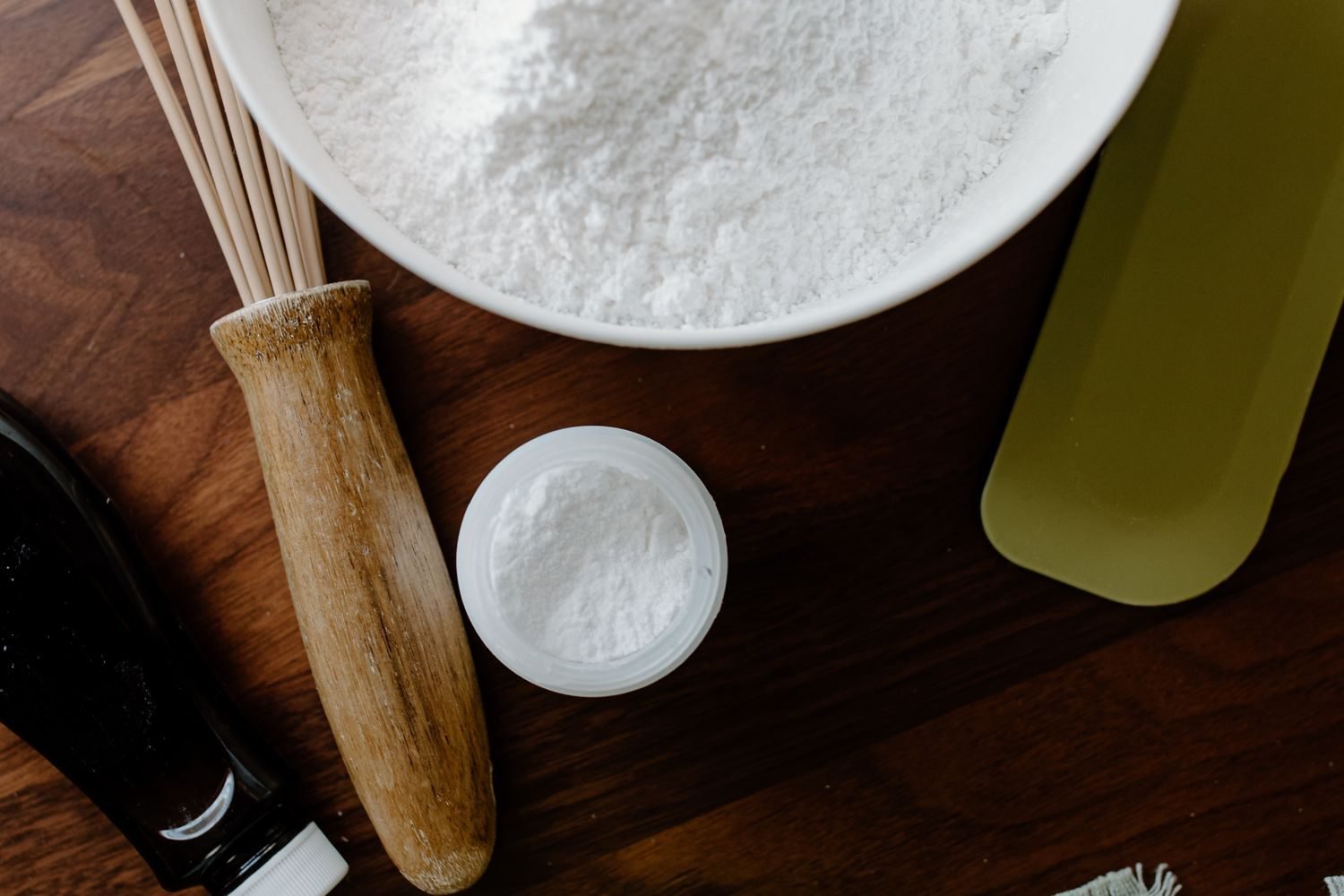 Side-by-side comparison of stevia leaf extract and white sugar in small bowls on a kitchen counter