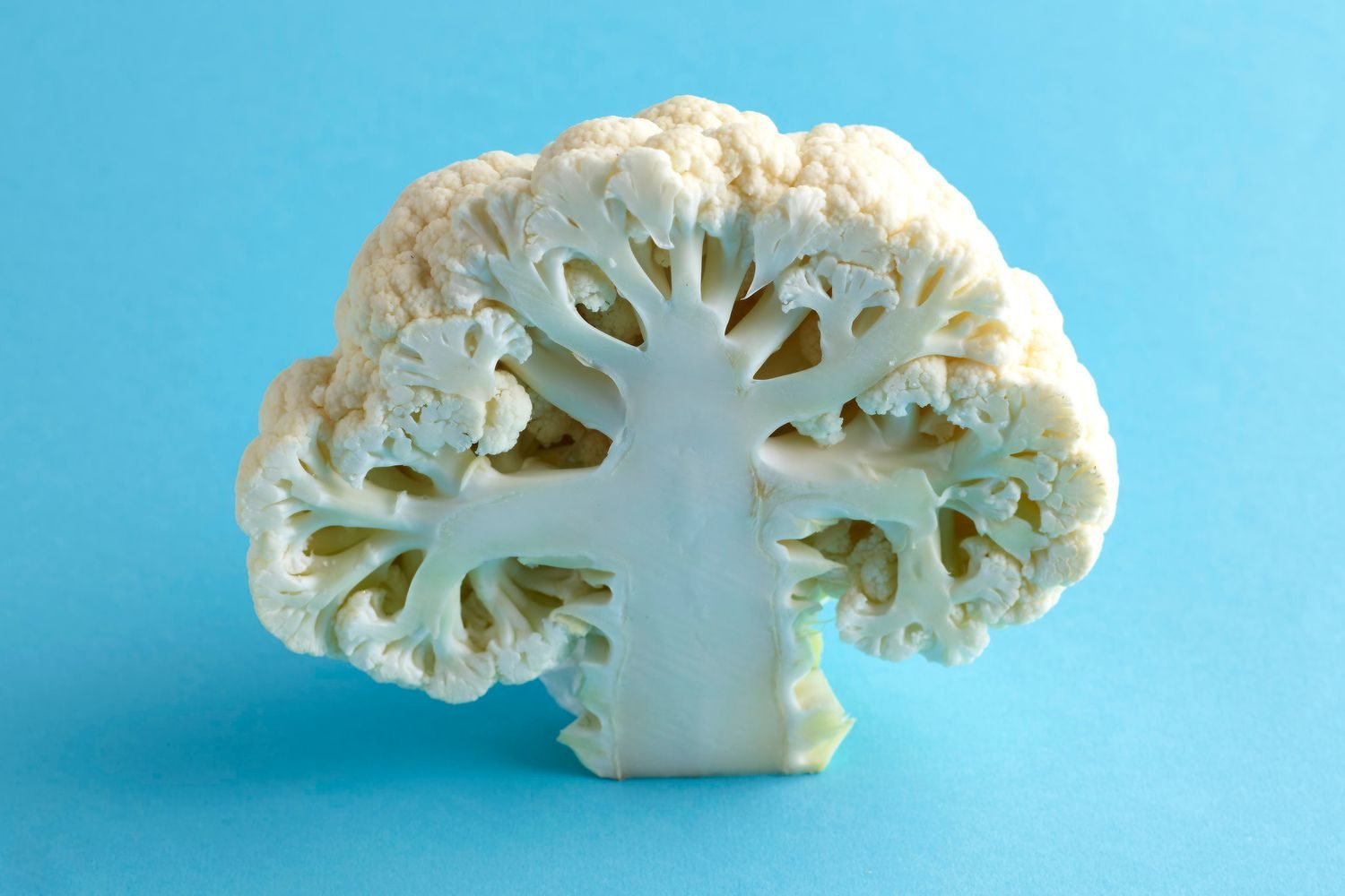 Fresh broccoli, cauliflower, kale, and cabbage on a cutting board representing cruciferous vegetables