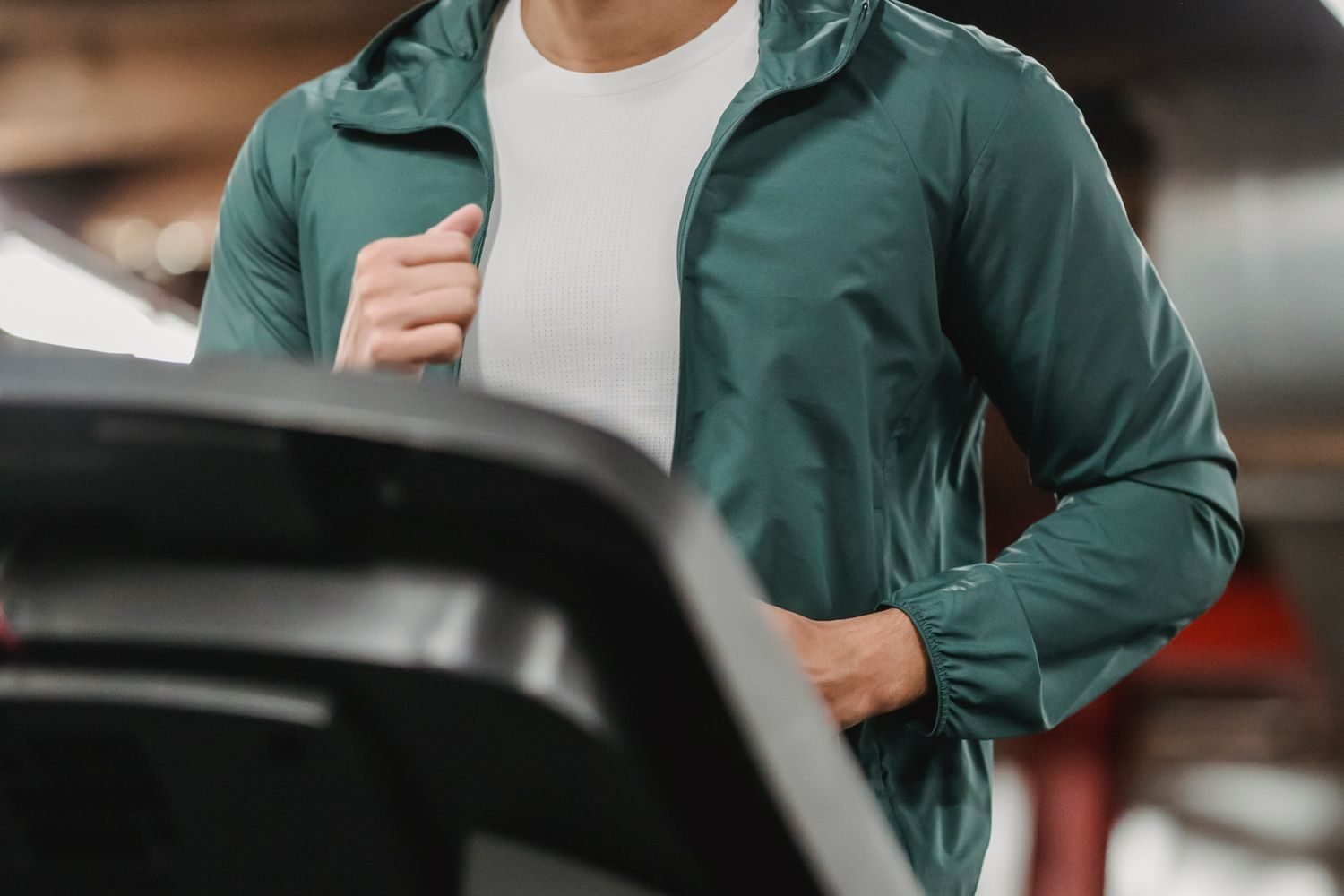 Close-up of a man jogging on a treadmill at the gym