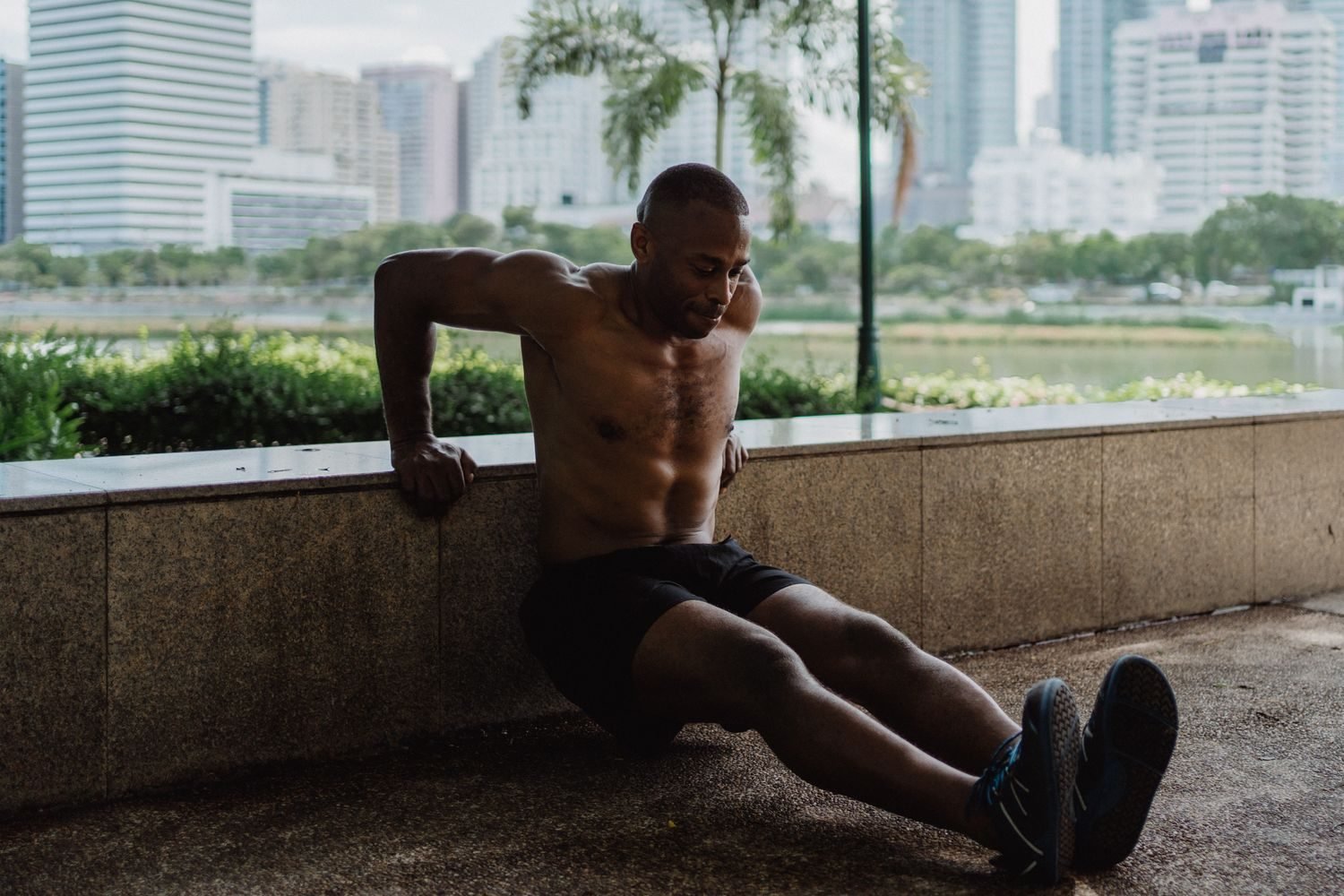 Man performing a tricep dip exercise outdoors