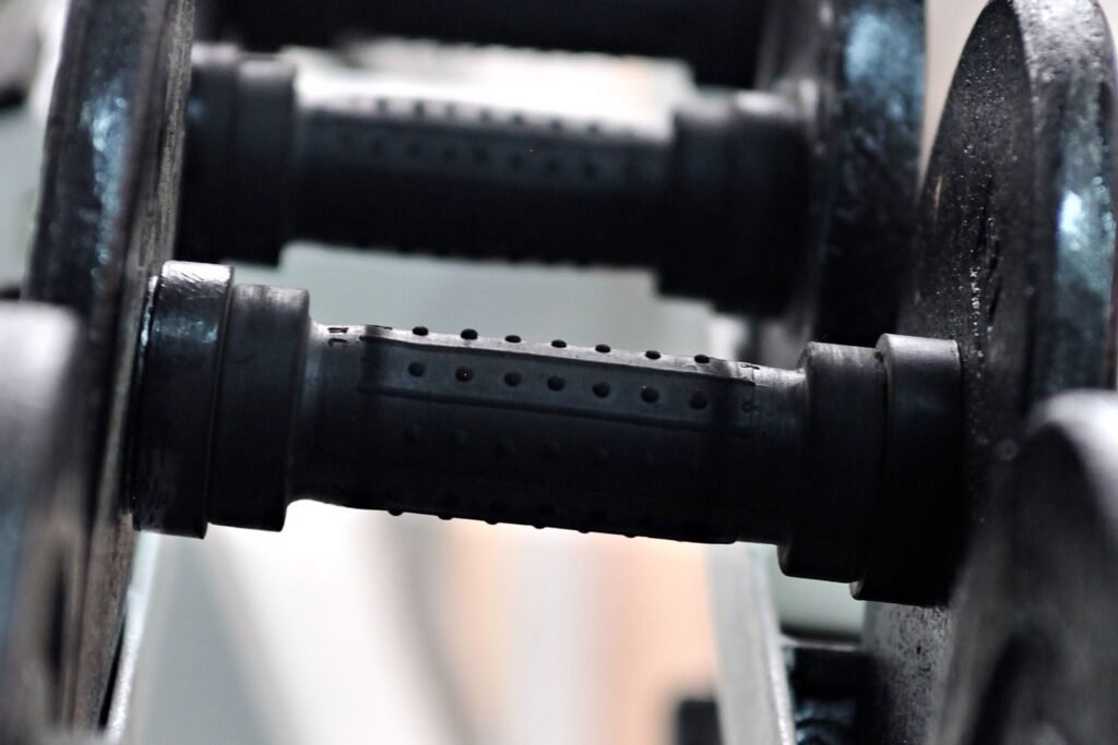 Close-up of black dumbbell handles racked in a gym