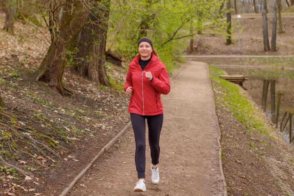 Woman jogging outdoors on a park path during a cardio workout
