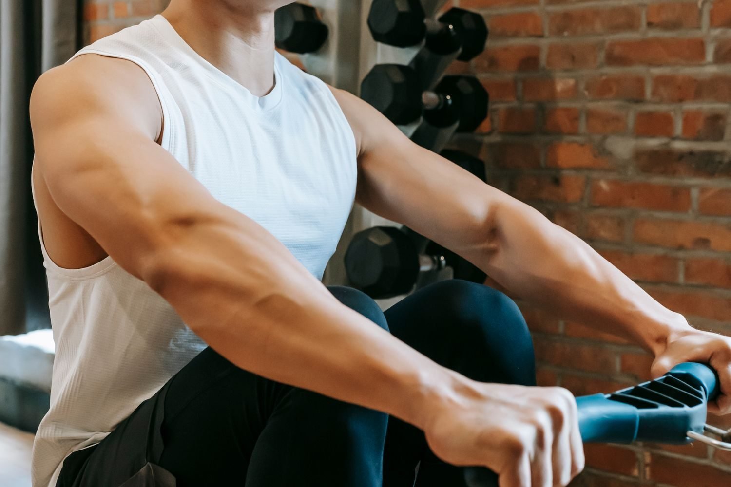 Man using a rowing machine at the gym to train his upper back