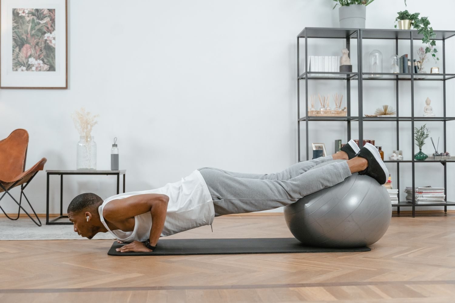 Man performing a decline push up with feet on a stability ball at home