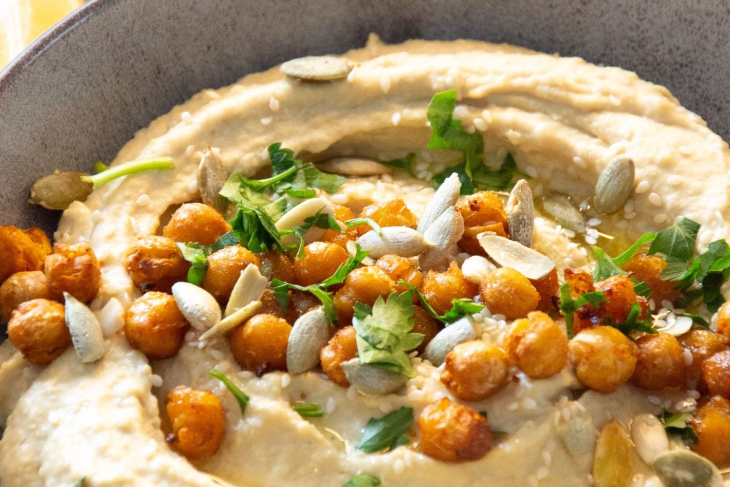 Bowl of soaked chickpeas, pumpkin seeds, spinach, and lemon representing iron and zinc absorption boosters for vegan diets
