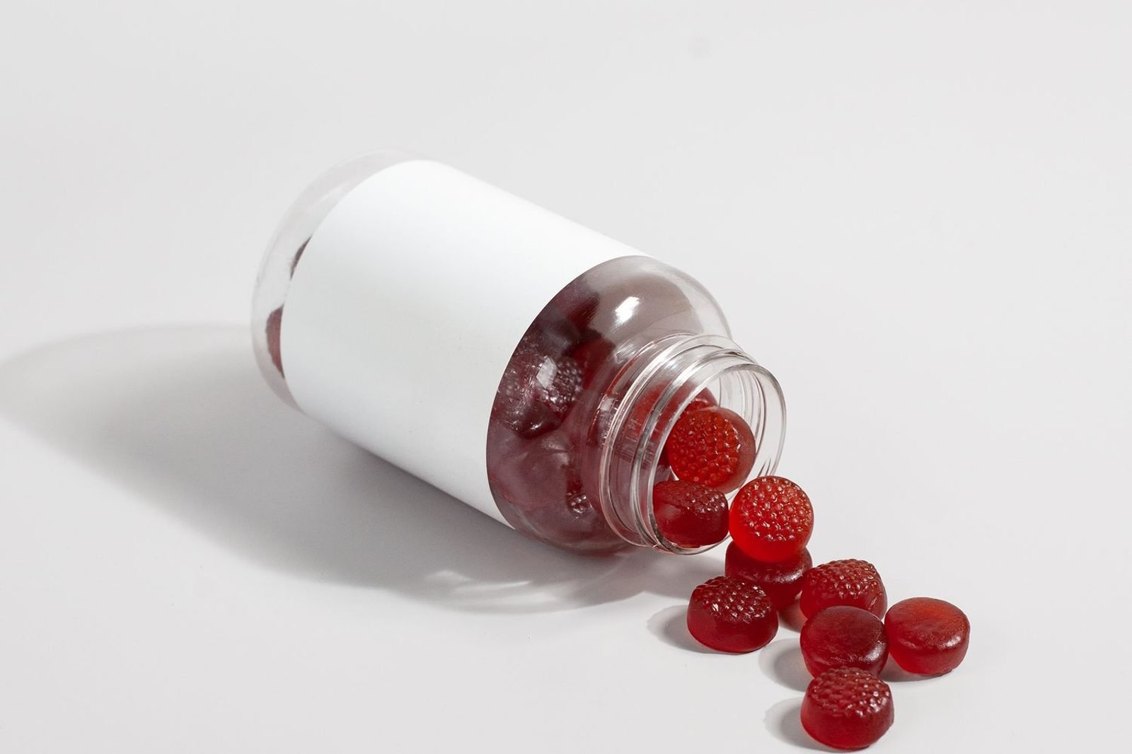Person reviewing a vitamin D and B12 supplement bottle alongside a plate of whole foods representing balanced vitamin nutrition