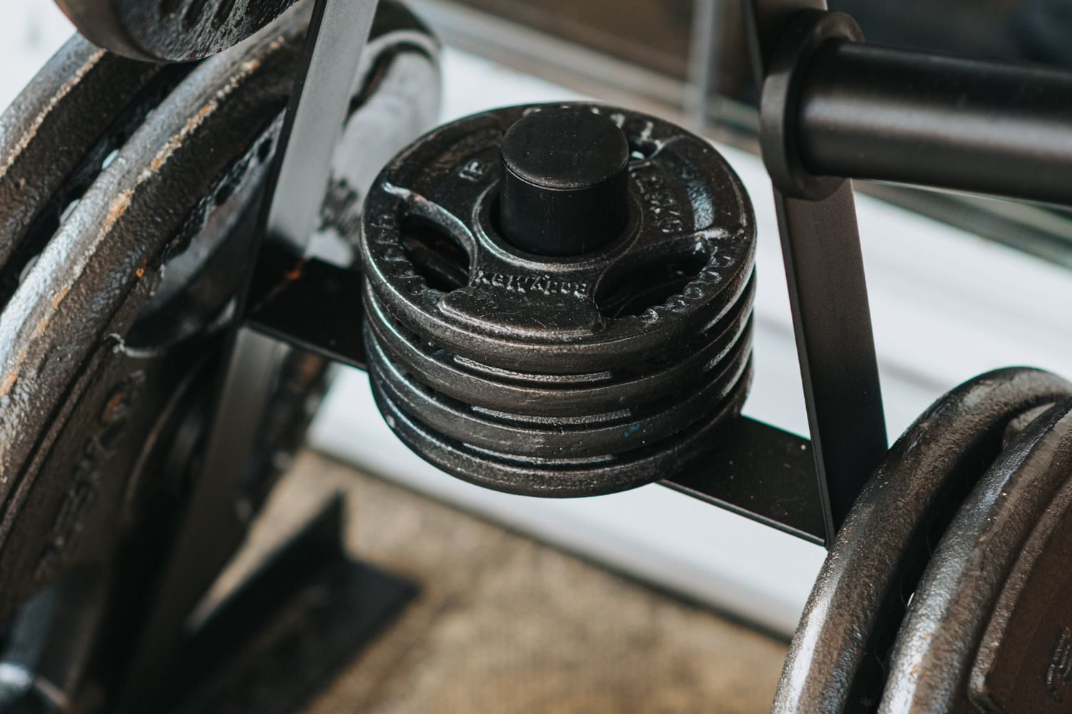 Close-up of weight plates stacked on a gym rack