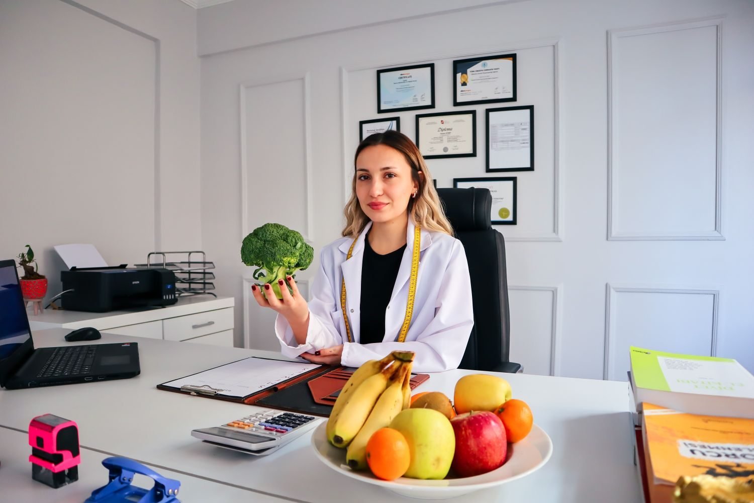 Person on a video call with an online nutritionist during a first consultation, laptop showing a diet chart